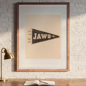 Jaws print in a Red Oak frame with a white mat, hanging above the desk in a home office.