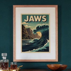 Jaws Maui Surf Travel Poster print in a Red Oak frame with a white mat, hanging above the sideboard in a green study.