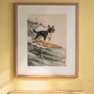 Boston Terrier Surfing print in a Red Oak frame with a white mat, hanging above the desk in a kids' room.