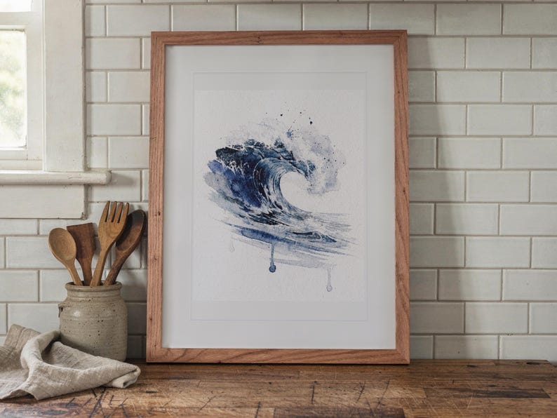 Prussian Blue Wave Watercolor print in a Red Oak frame with a white mat, leaning on the counter against the backsplash in a cottage kitchen.