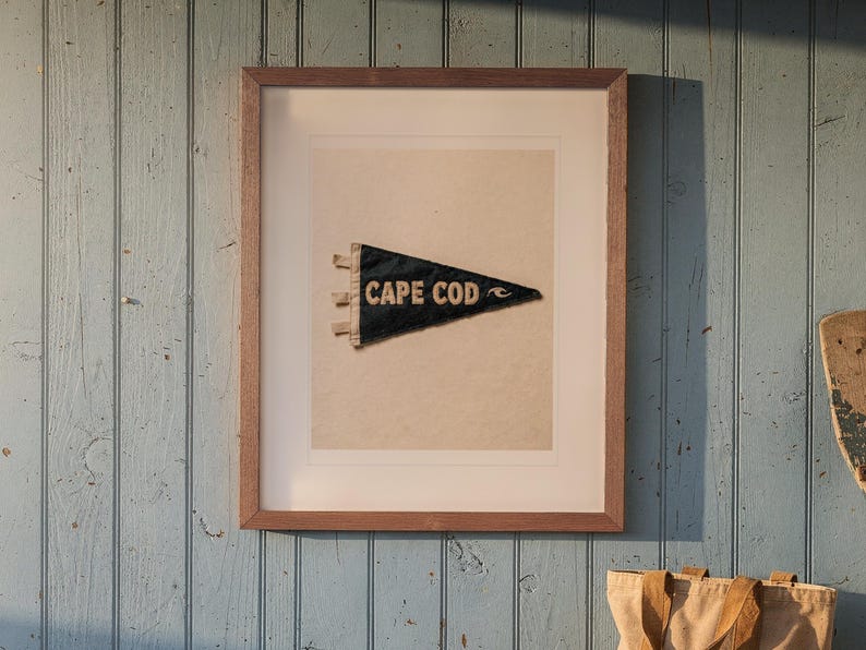 Cape Cod Surf Pennant print in a Red Oak frame with a white mat, hanging above the bench in a beach cottage entryway.