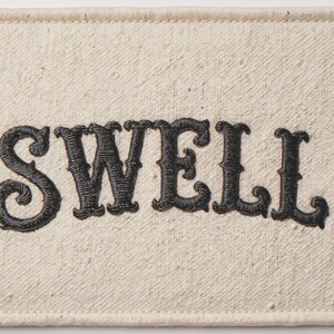Swell Embroidered Patch Print framed in a coastal dining room setting