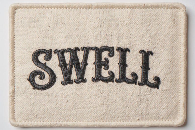 Swell Embroidered Patch Print framed in a coastal dining room setting