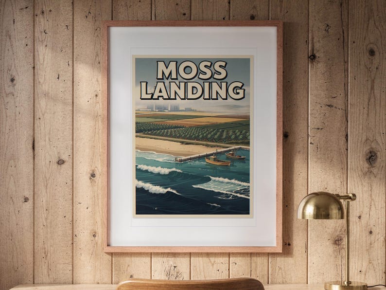 Moss Landing Surf Travel Poster print in a Red Oak frame with a white mat, hanging above the desk in a home office.