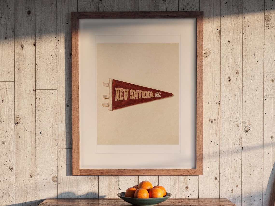 New Smyrna Beach Surf Pennant print in a Red Oak frame with a white mat, hanging above the dresser in a surf shack bedroom.