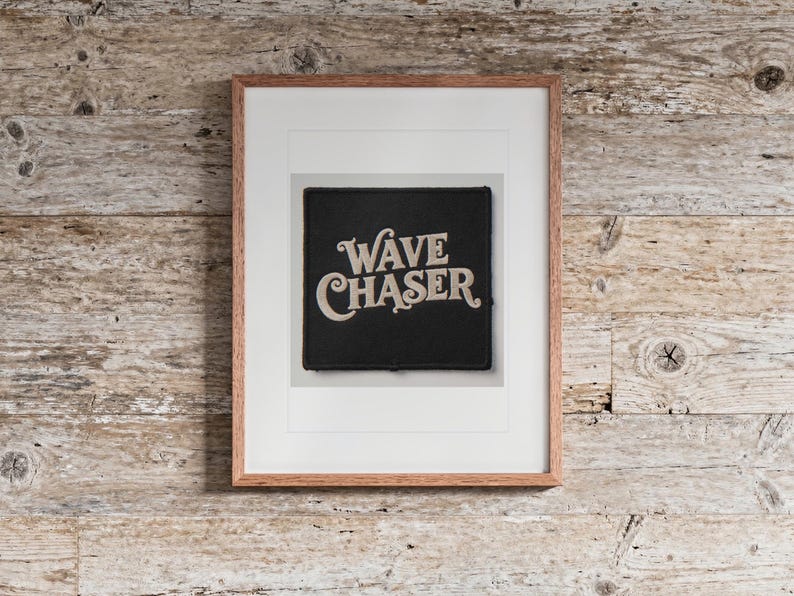 Wave Chaser Patch print in a Red Oak frame with a white mat, hanging above the bench in a beach house loft.