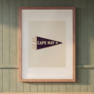 Cape May Surf Pennant print in a Red Oak frame with a white mat, hanging above the bench in a mudroom.
