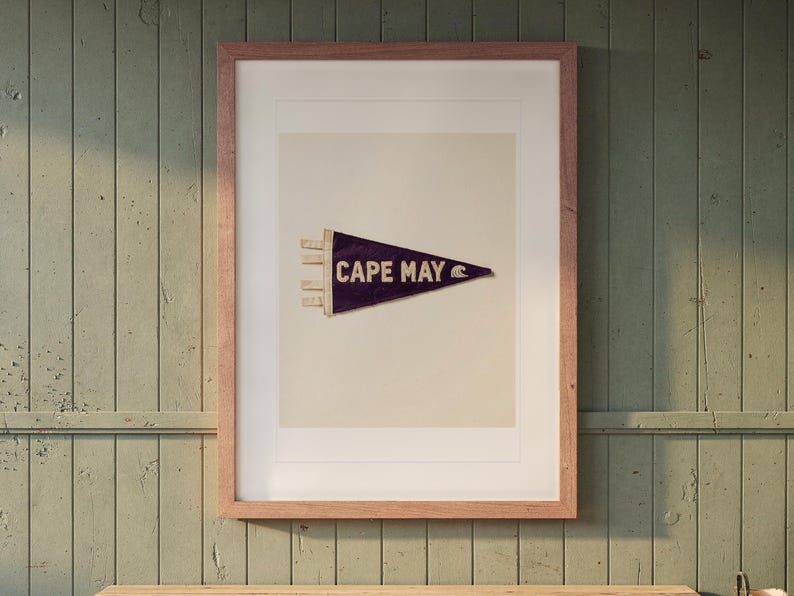Cape May Surf Pennant print in a Red Oak frame with a white mat, hanging above the bench in a mudroom.