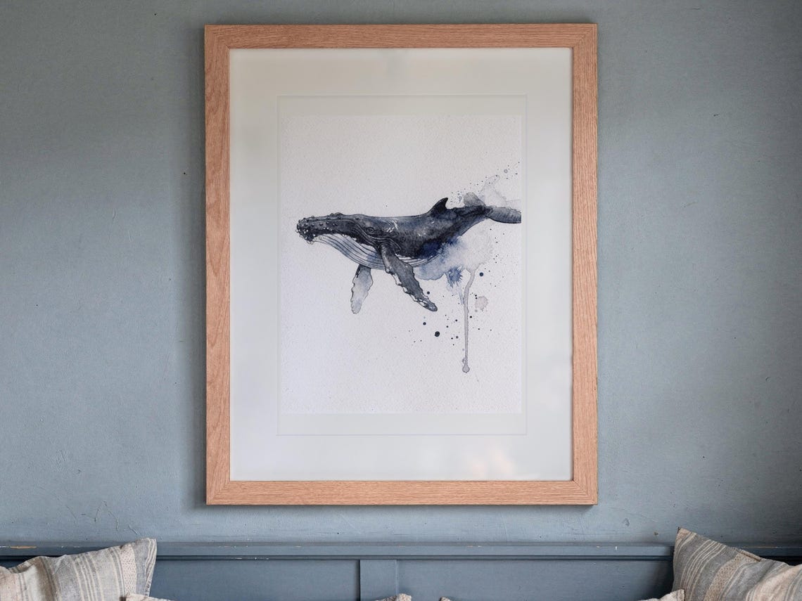 Humpback Whale print in a Red Oak frame with a white mat, hanging above the bench in a breakfast nook.