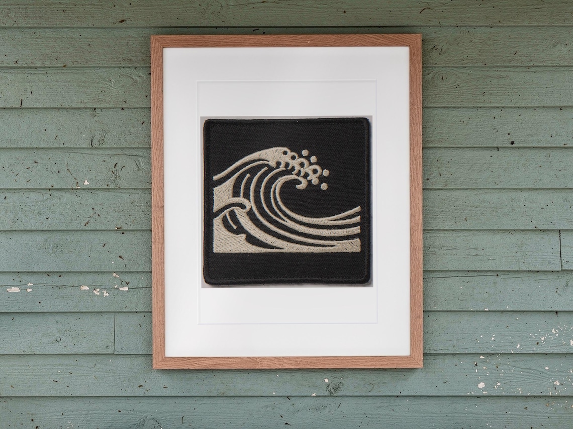 Wave Patch print in a Red Oak frame with a white mat, hanging above the bench in a screened beach porch.