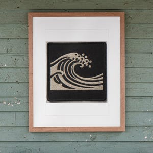 Wave Patch print in a Red Oak frame with a white mat, hanging above the bench in a screened beach porch.