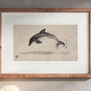 Leaping Dolphin Xieyi Ink print in a Red Oak frame with a white mat, hanging above the console in a japandi living room.