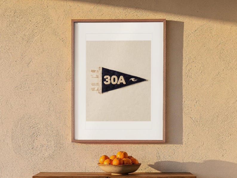 30A print in a Red Oak frame with a white mat, hanging above the console in a beach cottage entryway.