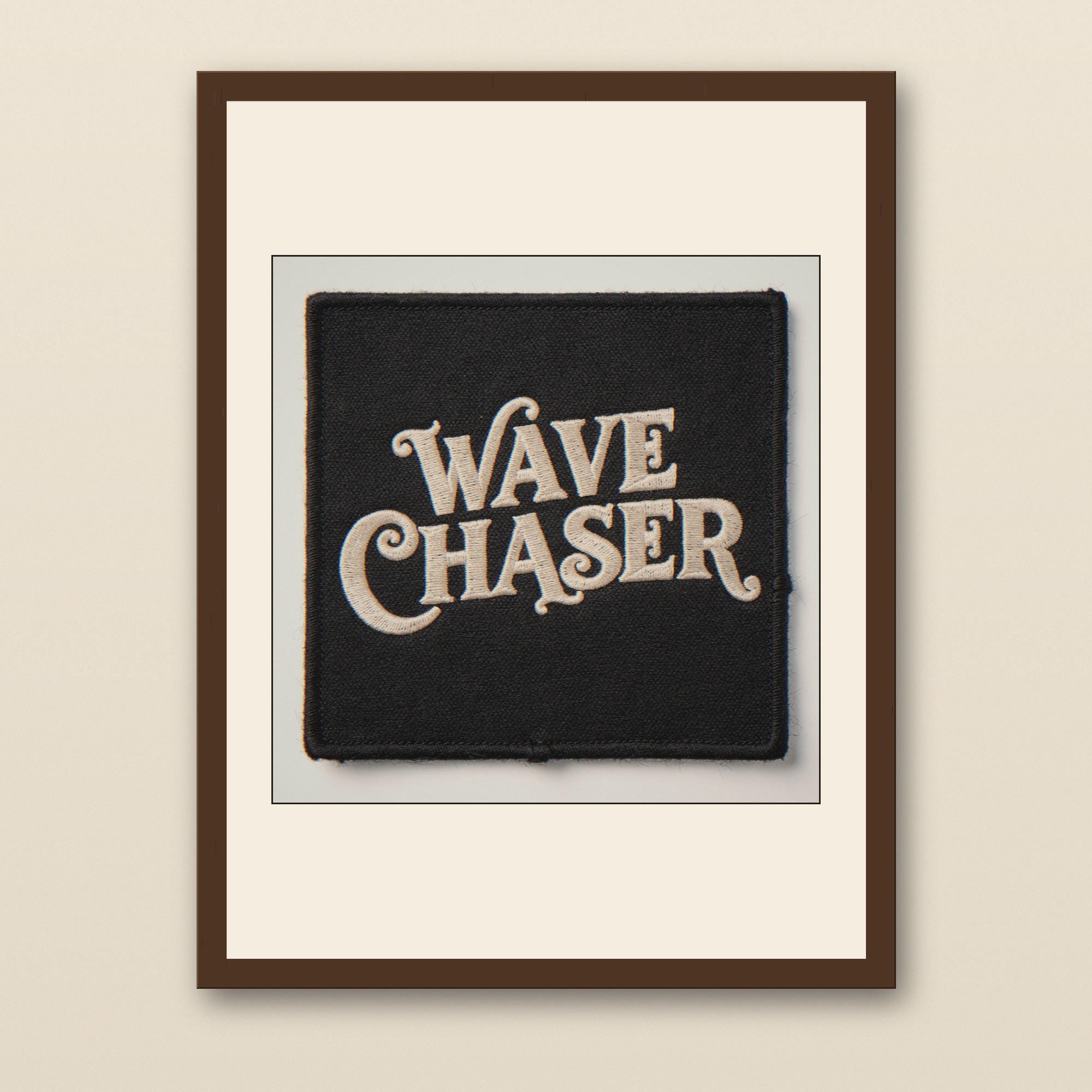 Wave Chaser Embroidered Patch Print - walnut framed art print with cream mat on plaster wall