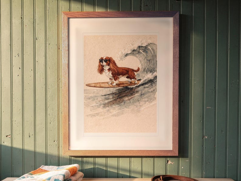 Cavalier King Charles Spaniel Surfing printable art, shown printed in a Red Oak frame with a white mat, hanging above the bench in a mudroom.