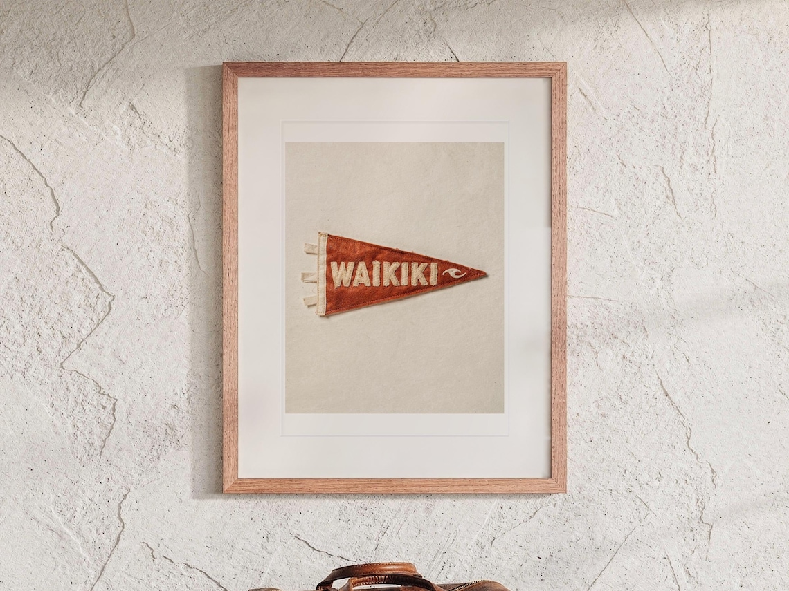Waikiki Surf Pennant print in a Red Oak frame with a white mat, hanging above the bench in a beach house loft.