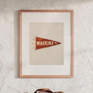 Waikiki Surf Pennant print in a Red Oak frame with a white mat, hanging above the bench in a beach house loft.