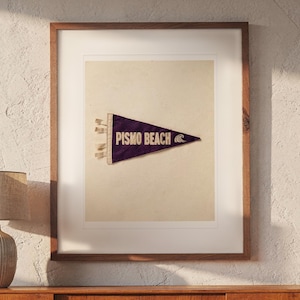 Pismo Beach print in a Red Oak frame with a white mat, hanging above the credenza in a mid-century living room.