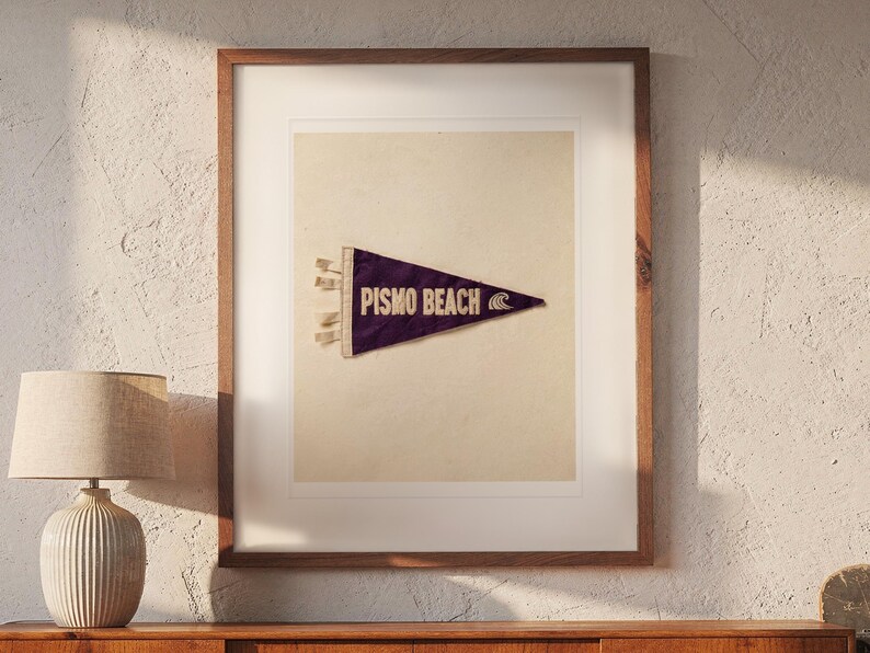 Pismo Beach print in a Red Oak frame with a white mat, hanging above the credenza in a mid-century living room.
