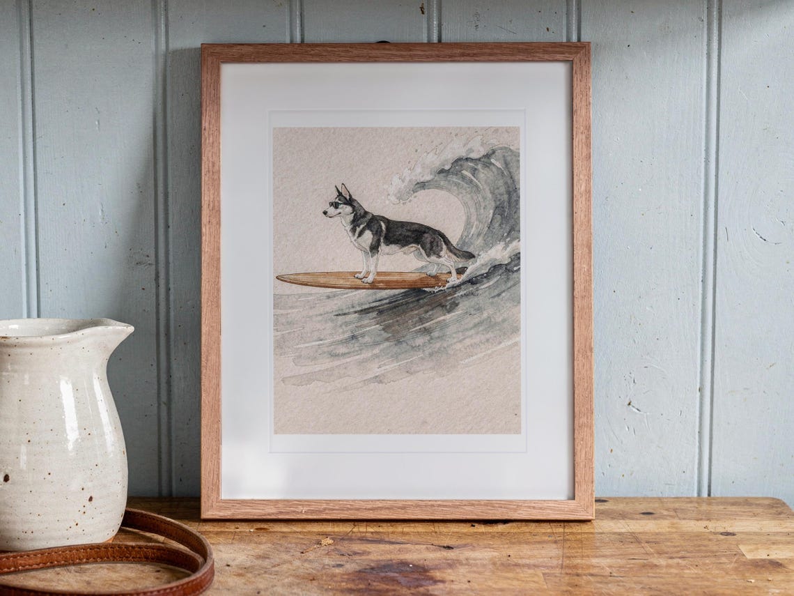 Husky Surfing print in a Red Oak frame with a white mat, leaning on the counter against the backsplash in a cottage kitchen.