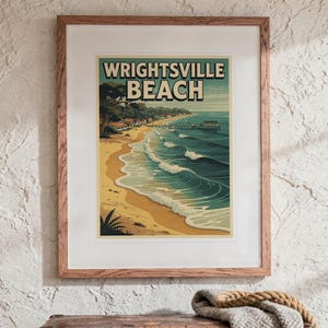 May include: A framed art print featuring a stylized illustration of Wrightsville Beach with sandy shores, rolling blue ocean waves, and a wooden pier. The text WRIGHTSVILLE BEACH is printed in bold, dark letters at the top of the artwork.
