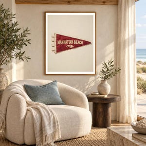 Manhattan Beach art print shown framed in a light-filled coastal living room (frame not included). RetroSwell digital download.