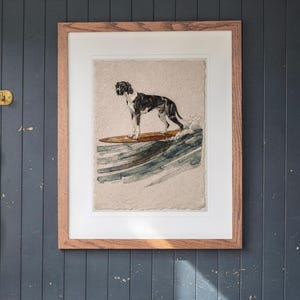 Great Dane Surfing printable art, shown printed in a Red Oak frame with a white mat, hanging above the cubbies in a mudroom.