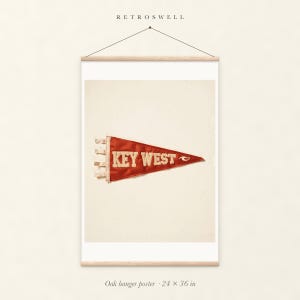 Key West Surf Pennant oak hanger poster, 24 by 36 inches, with natural wood rails and a hanging cord.