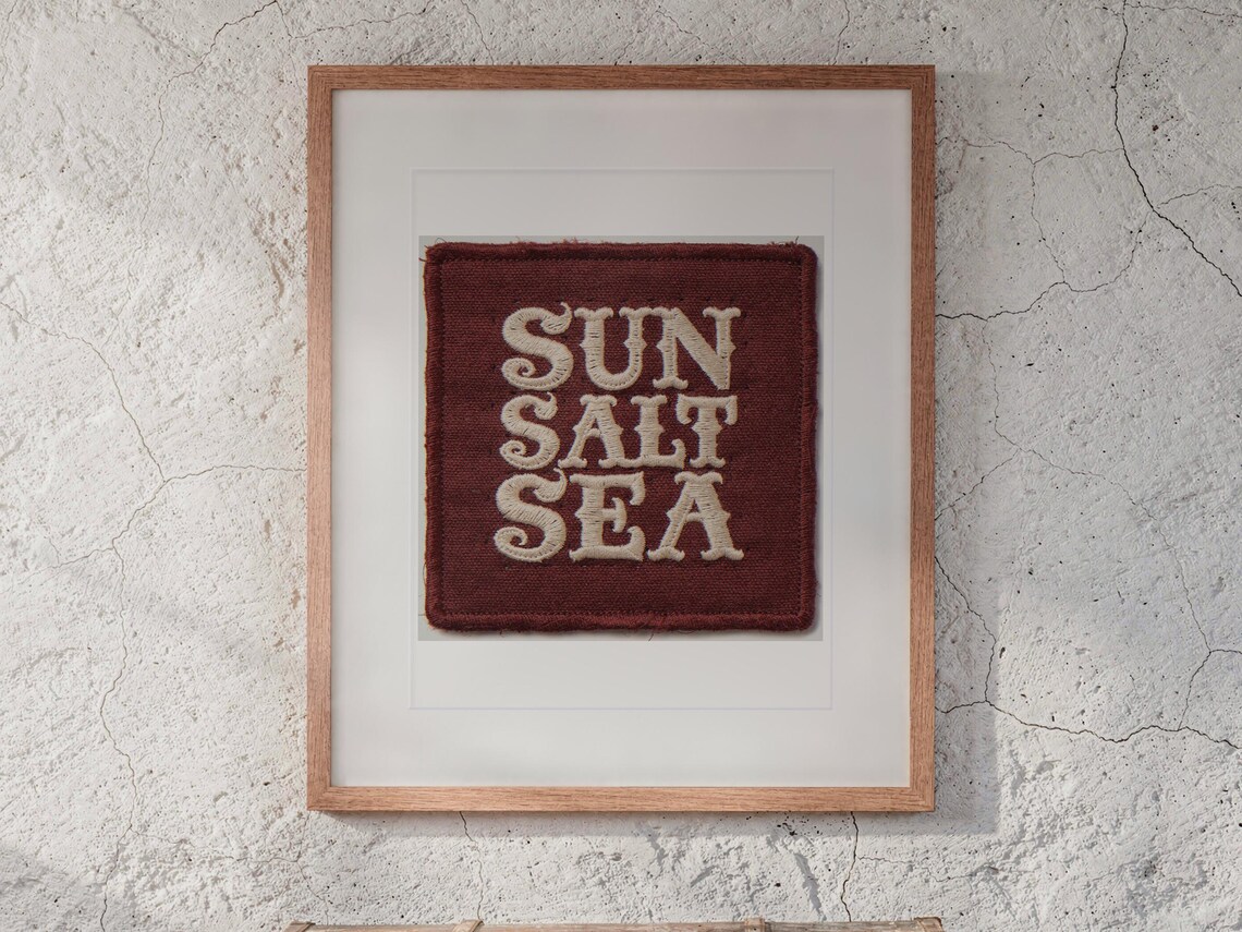 Sun Salt Sea Patch print in a Red Oak frame with a white mat, hanging above the trunk in a beach house loft.