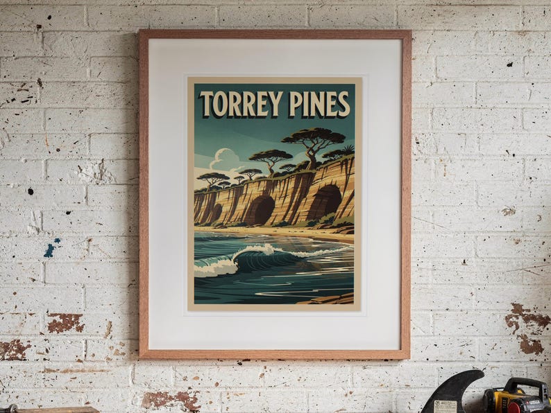 Torrey Pines Surf Travel Poster print in a Red Oak frame with a white mat, hanging above the workbench in a surf garage.
