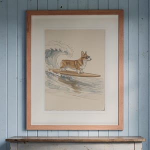 Corgi Surfing print in a Red Oak frame with a white mat, hanging above the console in a beach cottage entryway.