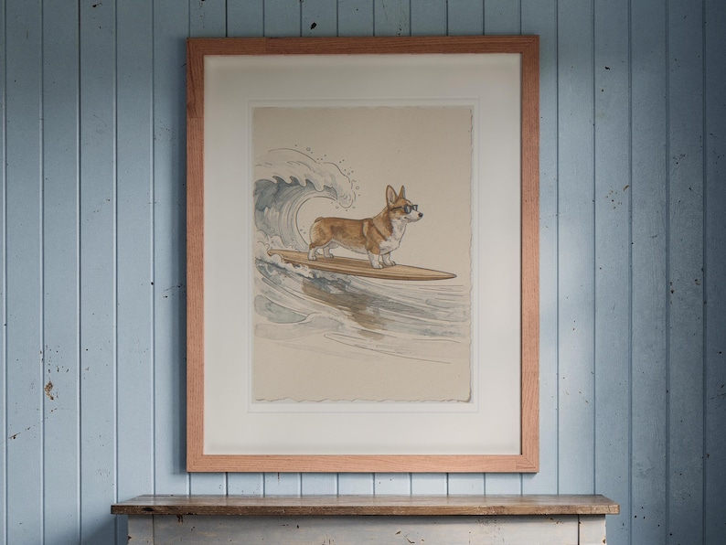 Corgi Surfing print in a Red Oak frame with a white mat, hanging above the console in a beach cottage entryway.