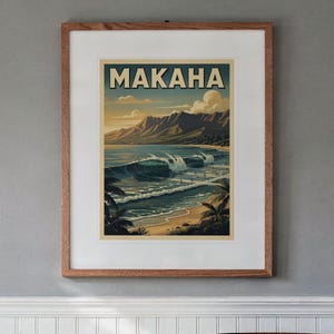 May include: A framed wall art print featuring a coastal landscape with the text MAKAHA at the top. The illustration depicts blue ocean waves breaking near a sandy beach with palm trees in the foreground and mountains under a cloudy sky.