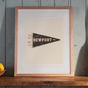 Newport print in a Red Oak frame with a white mat, leaning on the shelf against the wall in a cottage kitchen.