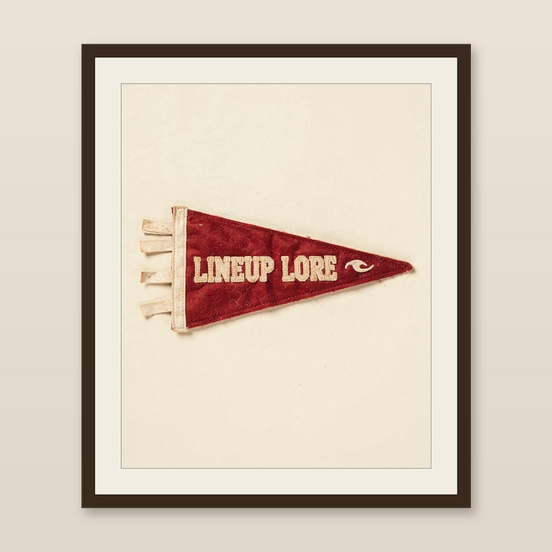 Lineup Lore vintage felt surf pennant printable displayed in a warm wood frame on a softly lit neutral wall