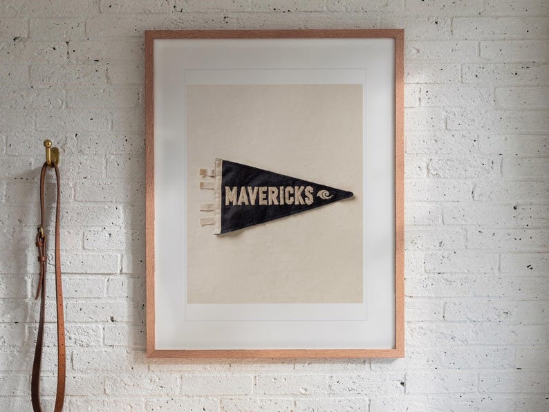 Mavericks Surf Pennant print in a Red Oak frame with a white mat, hanging above the bench in a mudroom.