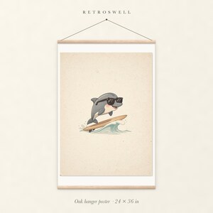Dolphin Surfing oak hanger poster, 24 by 36 inches, with natural wood rails and a hanging cord.