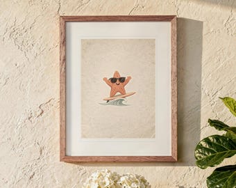 May include: A framed wall art print featuring a cartoon starfish wearing black sunglasses while surfing on a surfboard atop a stylized blue wave. The illustration is centered on a textured, light beige background within a wooden frame.