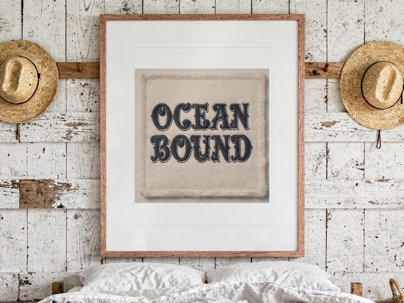 Ocean Bound Patch print in a Red Oak frame with a white mat, hanging above the bed in a surf shack bedroom.