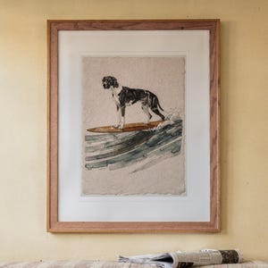 Great Dane Surfing print in a Red Oak frame with a white mat, hanging above the bench in a breakfast nook.