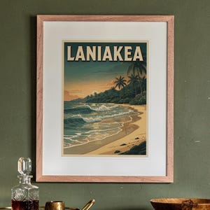 May include: A framed art print featuring a beach scene with the text LANIAKEA at the top. The illustration depicts ocean waves rolling onto a sandy shore, palm trees, and a sunset sky in shades of blue, orange, and cream, enclosed in a light wood frame.