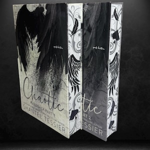 May include: Two hardcover books titled "Chaotic" by Shantel Tessier. The book covers feature black angel wing designs against a white and gray background. The spine of the books have a feather and wing design.