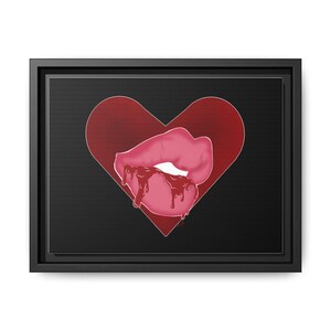 May include: A framed canvas art print. The image shows a pair of pink lips with dripping red liquid, set against a red heart shape on a black background. The canvas is in a black frame, suitable for wall display.