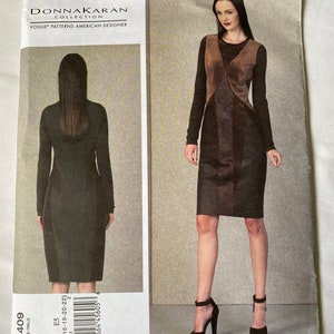 May include: A Donna Karan Collection Vogue Patterns American Designer sewing pattern. The pattern features a long-sleeved dress with a color-blocked design. The dress is shown in a dark color with a contrasting panel.