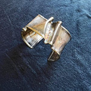 Bracciale modernista piegato in argento firmato LOLA