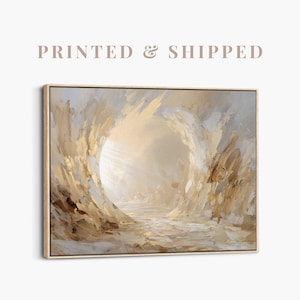 May include: Abstract canvas art print in neutral tones. The artwork depicts a central, bright, circular form surrounded by textured brushstrokes in beige, gold, and grey. The canvas is framed in light wood.