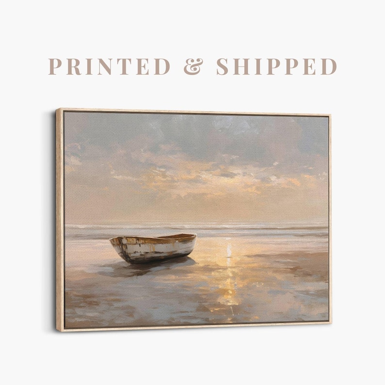 May include: A framed canvas print of a serene beach scene. A small, weathered boat rests on the shore, reflecting the warm hues of a sunset. The sky is painted with soft clouds and golden light. The text "PRINTED & SHIPPED" is at the top.