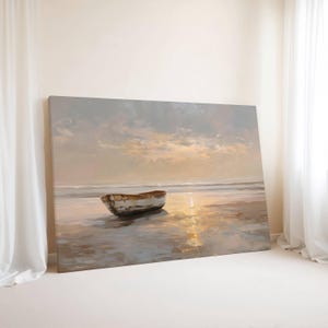 May include: A canvas print of a serene beach scene. A small, weathered boat rests on the wet sand, reflecting the soft light of the setting sun. The sky is filled with pastel colors, creating a peaceful and calming atmosphere. The artwork is displayed on a white wall.