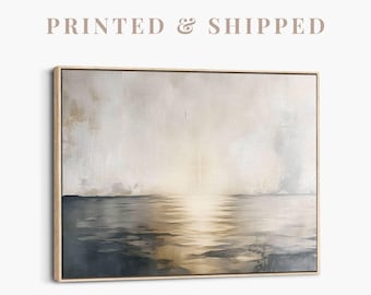 May include: A framed canvas art print depicting a seascape. The artwork features a muted color palette with shades of gray, beige, and gold. The text "PRINTED & SHIPPED" is printed above the artwork. The painting shows a calm ocean reflecting the sky.