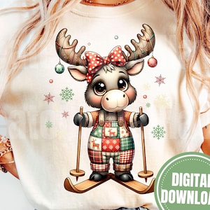 May include: A cream-colored t-shirt featuring a cartoon moose wearing a red bow, plaid overalls, and skis. The moose has antlers decorated with ornaments and is surrounded by snowflakes. A green circle with the words "DIGITAL DOWNLOAD" is on the bottom right.